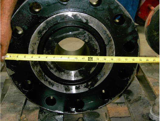 Industrial flange being measured with tape measure